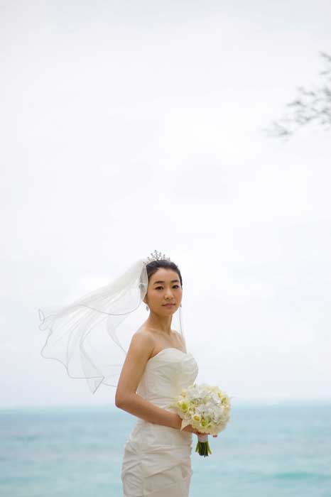 sung the bride holding her white hawaiian bouquet